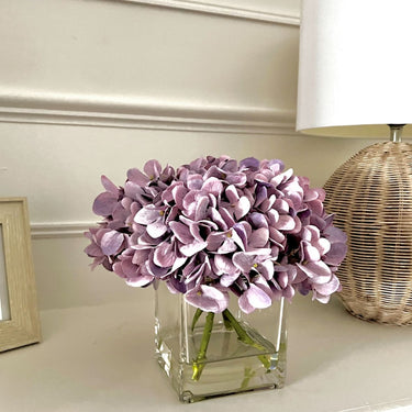 Mauve/Lilac Hydrangea arrangement in cubed glass vase