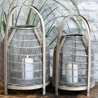 Mesh and wicker lantern with handle and glass candle holder in lifestyle photo