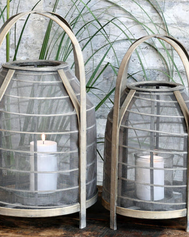 Mesh and wicker lantern with handle and glass candle holder in lifestyle photo