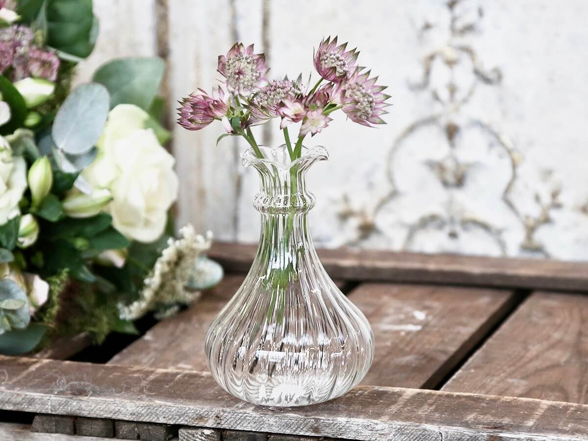 Glass bud vase with ribbed etching in lifestyle photo