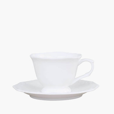White cup and saucer set with french design on white background
