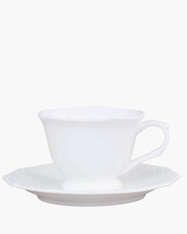 White cup and saucer set with french design on white background