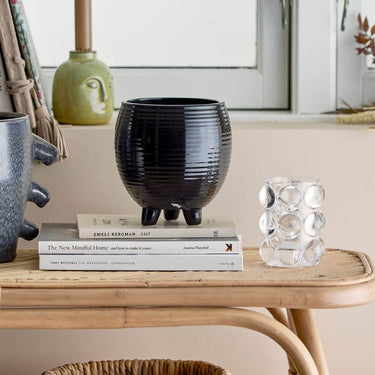 Black glazed flower pot on feet in lifestyle photo