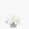 Faux silk Hydrangea arrangement in cubed glass vase on white background