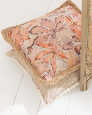 Pink, peach and cream floral cushion with jute surround and zipper on lifestyle photo
