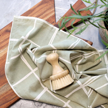 Green tea towel with cream stripe on a lifestyle background